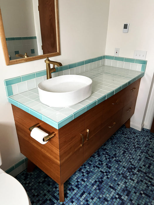 Modwalls Mediterranean Mosaic Porcelain Tile | Cannes Blend Gloss | Blue | Pictured on a bathroom floor | Colorful Modern & Midcentury tile for bathrooms, kitchens, backsplashes, showers, floors, pools & outdoors. 
Vanity tile: Lush Glass Subway Tile Cloud 4x4 | White | Colorful Modern glass tile for bathrooms, showers, kitchen, backsplashes, pools & outdoors.