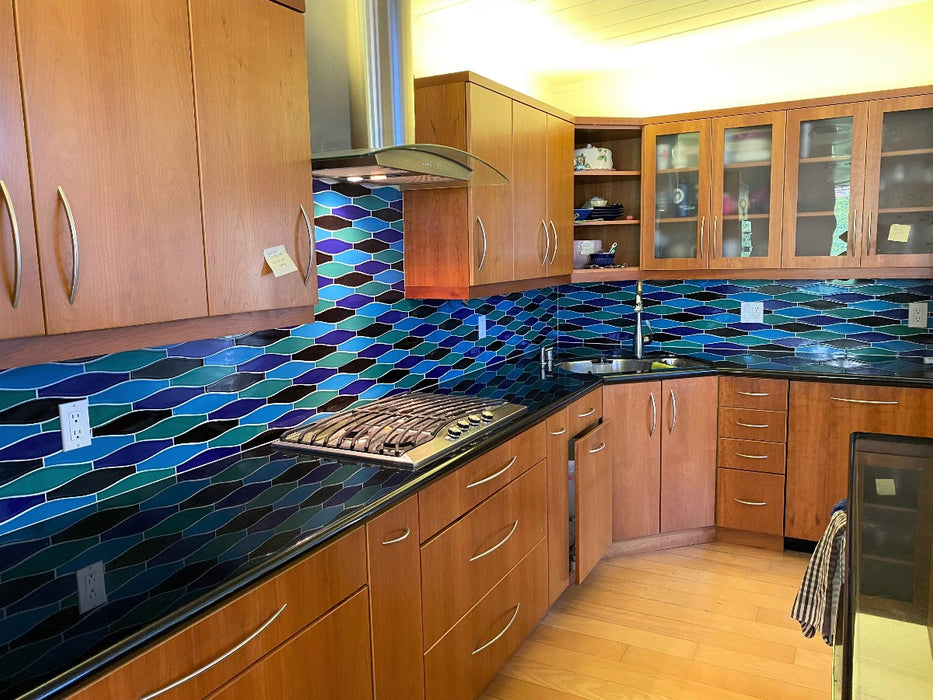 A bold combination of glossy black , teal and bright blue in a smooth minnow shaped ceramic tile backsplash. Kiln Ceramic tile is custom made in 105 colors and a unique variety of shapes. It's great for bathroom, kitchen and backsplash applications.