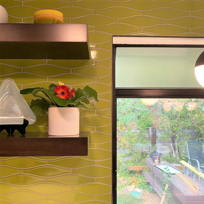 A soft and bright green minnow shaped accented by dark wood trim and open shelving gives this kitchen pizazz. This hand crafted tile is made to order in 105 colors and is perfect for kitchens, backrooms and backsplashes.
