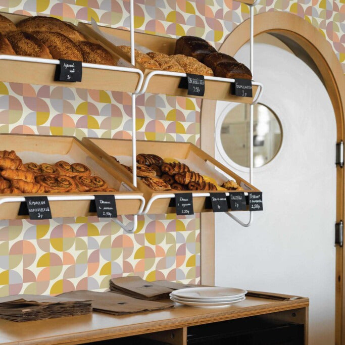 Modwalls ModPaper | ModSpring | Purple, green, blue and pink repeating wallpaper design | Pictured installed in a bakery | Colorful Midcentury and Retro wallpapers for bathrooms, kitchens, living rooms, dining rooms, baby rooms, kid’s rooms, and offices. 
