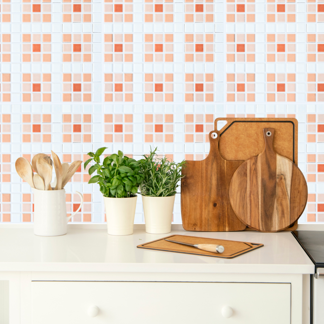 Modwalls Vita Custom Midcentury and Retro Patterns | Blossom Pattern | gloss porcelain mosaic 1x1 tile pattern of nine squares with an x in the middle of each | Image depicts pattern with white, off-white, peach and melon colored tiles installed on a kitchen wall | Choose your pattern colors from 58 color choices. Colorful tile suitable for indoor, outdoor, floor, wall, wet or dry. This tile is perfect for backsplashes, kitchens, bathrooms, showers, feature areas and commercial projects.