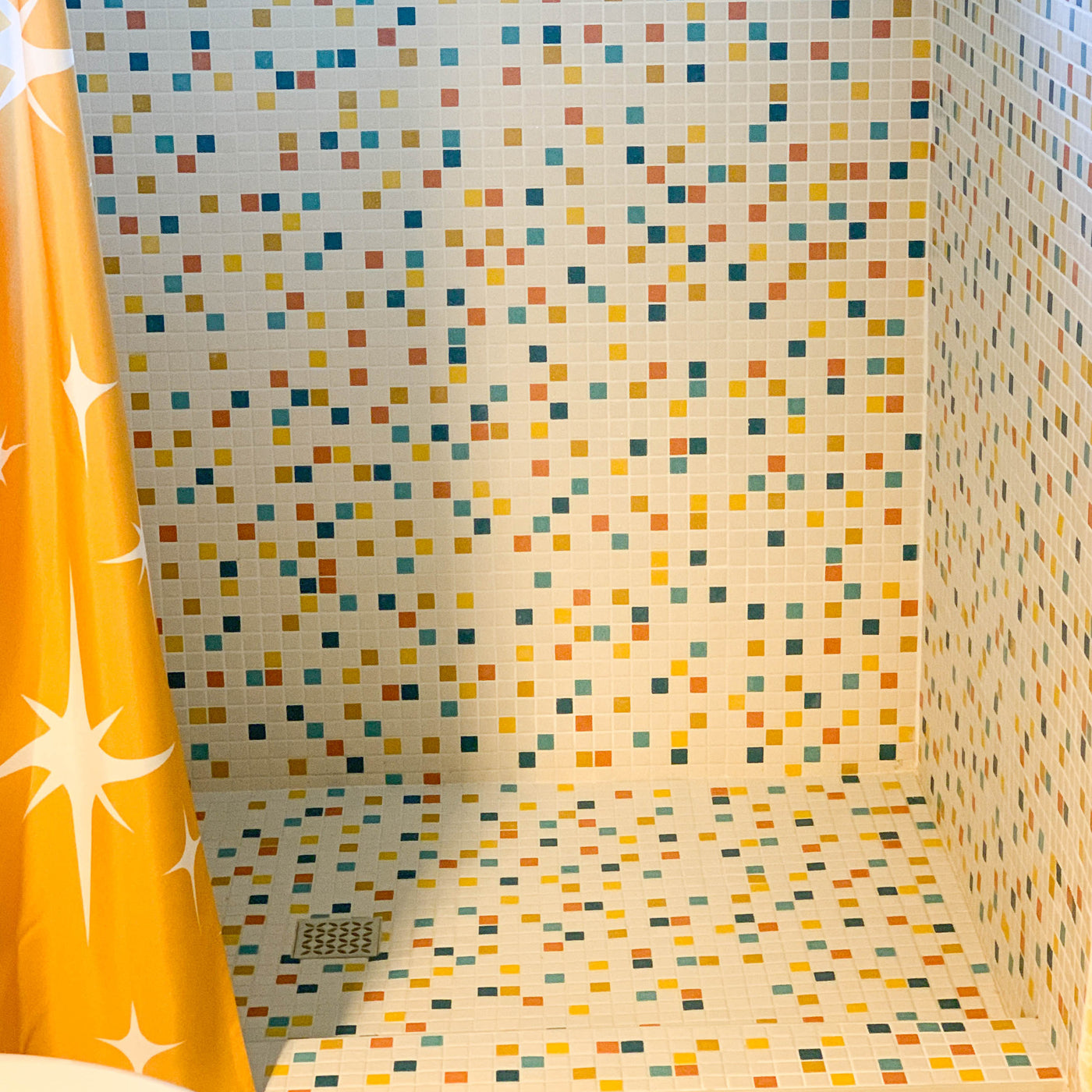 Modwalls Vita Mosaic Porcelain Tile in MCM Blend | Midcentury modern style white, orange, blue and red mosaic tiles | Pictured installed in a shower | Colorful Midcentury and Modern tile for backsplashes, kitchens, bathrooms, showers, floors, outdoor & feature areas. 