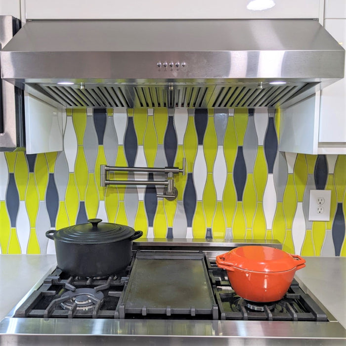 Kiln Ceramic Minnow shaped Tile in Chartreuse, Snow White & Caspian Blue layed vertically in this modern kitchen backsplash. Our minnow tile is a classic Mid Century shape refined just for us and is perfect for kitchens, backsplashes, bathrooms & showers